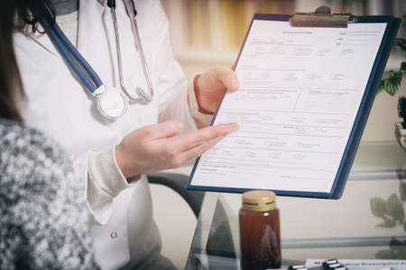 Medical doctor presenting medical history form to her patientの写真素材