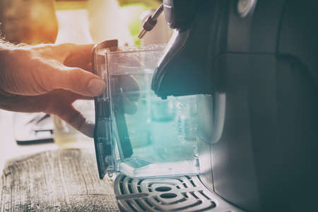 Water refill in coffee machine, a container in handの写真素材