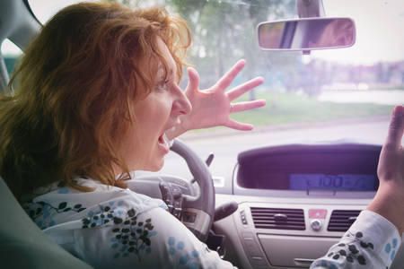 Angry woman screaming and gesturing while driving a car. Negative human emotions concept