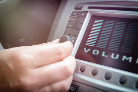 Driver using knob to adjust volume in the car audio systemの写真素材