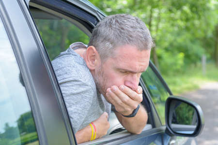 Man suffering from motion sickness in a car