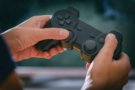 Mature woman or wife plays video game using the gamepad at home