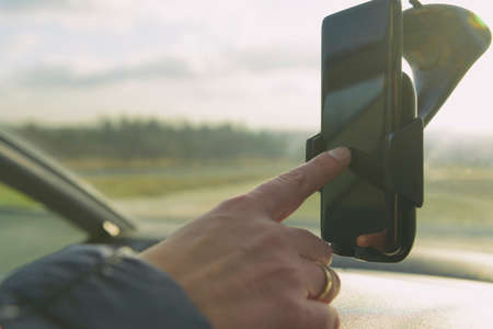 Woman using smart phone as navigation while driving the car. Risky driving behaviors concept