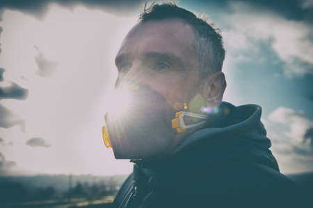 man wearing a real anti-pollution, anti-smog and viruses face mask; dense smog in airの写真素材