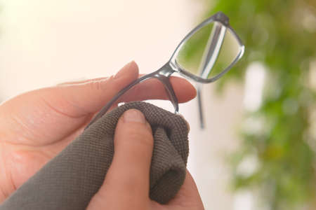 Woman cleaning eyeglasses with microfiber clothの写真素材