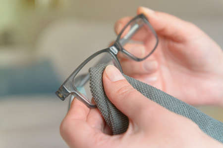Woman cleaning eyeglasses with microfiber clothの写真素材