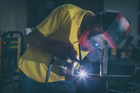 Industrial Worker at the factory or workshop welding steel elements