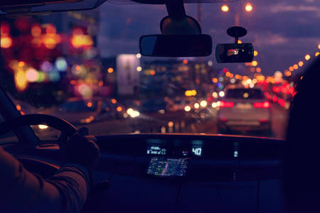 Driving a car in the city at night in traffic jams. A concept of a difficult return homeの写真素材