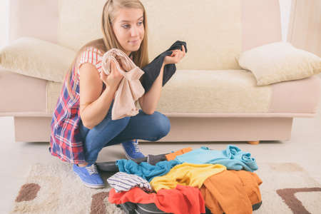 Young girl packing a suitcase for a holiday trip