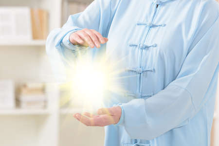 Beautiful woman doing qi gong tai chi exercise at homeの写真素材
