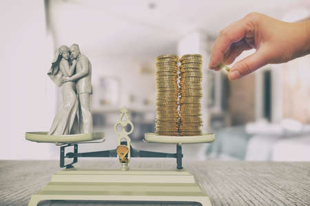 The figurine young couple husband and wife are standing on the scale, coins are lying on the opposite side of the scale; 3d illustrationの写真素材