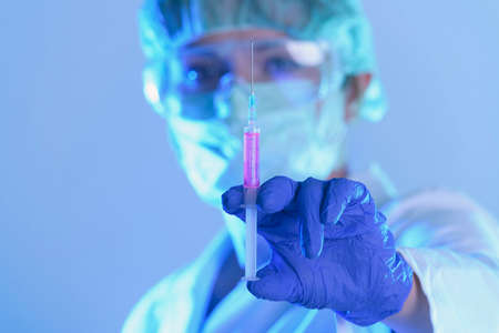 scientist working in a laboratory holding a syringe with a new anti-viral drug