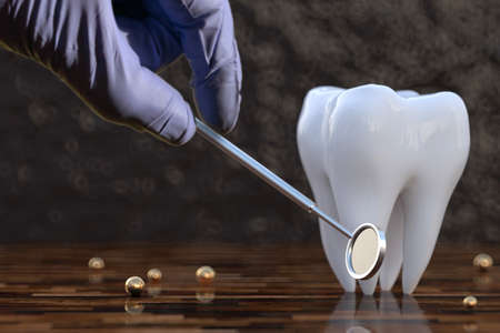 Dentist's hand with a dental mirror near a tooth. Concept of dental care and regular dental checkup...