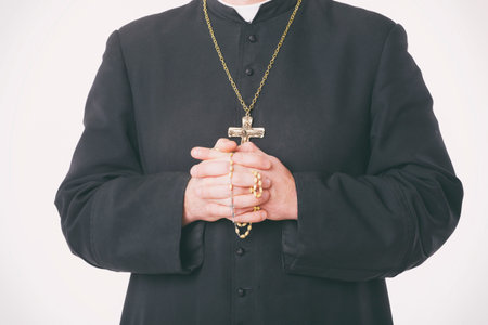 Catholic priest's hands holding the rosaryの写真素材