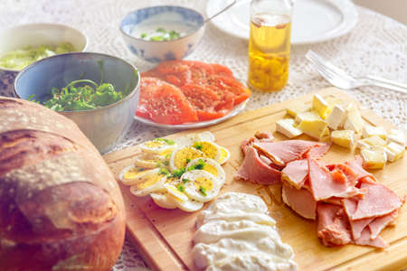 Continental, healthy breakfast containing homemade bread, vegetables tomatoes, argula, sald, cheese...