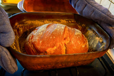 Traditional wheat and rye bread baked at home in a clay pot known as a Roman pot