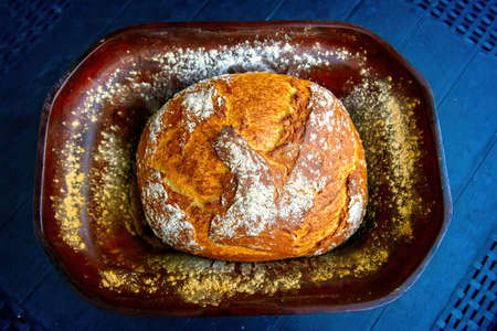 Traditional wheat and rye bread baked at home in a clay pot known as a Roman pot