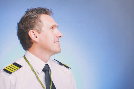 Smiling male airplane captain looks ahead