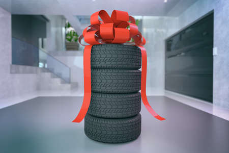 Four tires stacked on top of each other with red bow in garage. Good graphics for a tire store, storage room, tire service. 3d illustration on white.の写真素材
