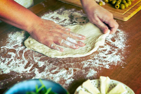 Preparing the Italian pizza. Kneading yeast dough pizza in handsの写真素材