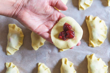 Making dumplings filled with sour cherry with sugarの写真素材