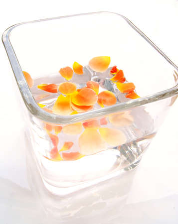 Rose petals orange in glass jar isolated on whiteの写真素材