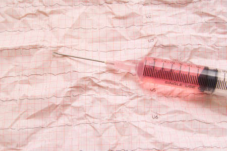 Syringe on electrocardiogram paperの写真素材
