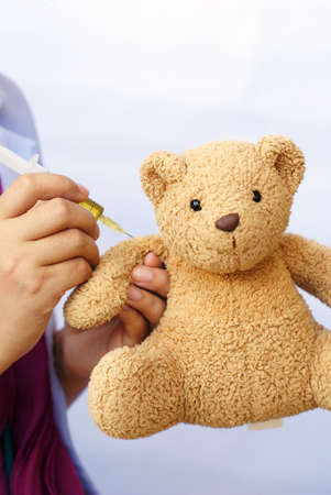 hand injecting the Teddy against white backgroundの写真素材