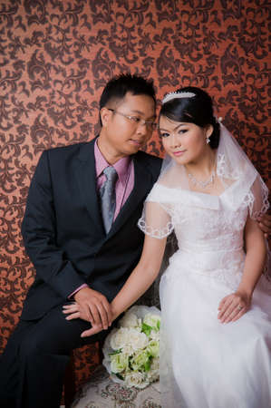 Bride and Groom posing in wedding dress at studio, smilingの写真素材