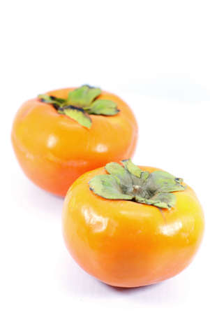 Two ripe persimmons isolated on white の写真素材