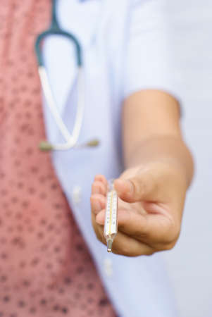 a nurse show a thermometerの写真素材