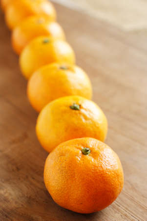 orange in a row on wooden boardの写真素材