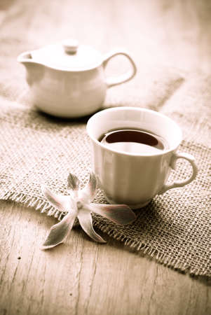 cup of tea with beautiful orchid over wooden background, sepiaの写真素材