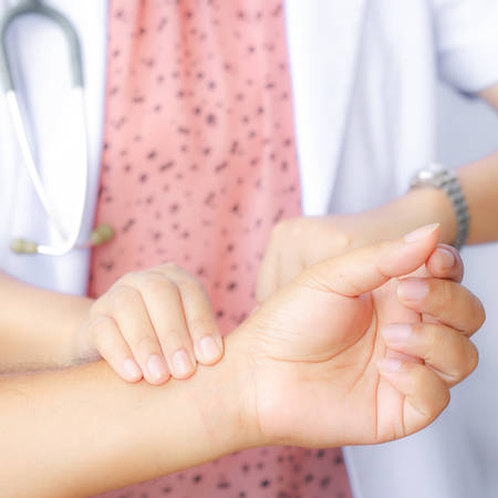 healthcare and medical concept - doctor or nurse with patient measuring pulse, check pulseの写真素材