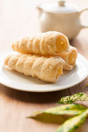 Cream-filled pastry roll on the wood boardの写真素材