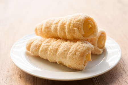 Cream-filled pastry roll on the wood boardの写真素材