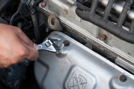 Hands of car mechanic in auto repair service 