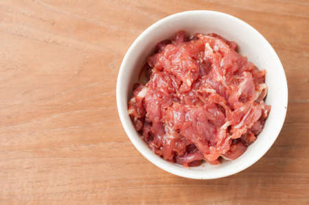 raw beef in white bowl on wooden backgroundの写真素材