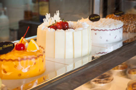 Window of a cake shop with a variety of cakes on displayの写真素材