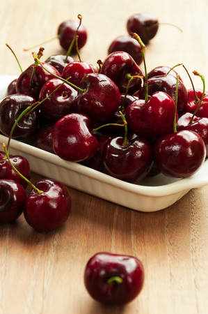 Fresh cherries in bowl on tableの写真素材