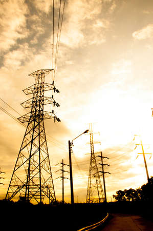 Energy Distribution Network - Electricity Pylons against Orange and Yellow Sunsetの写真素材