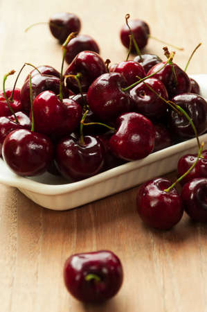 Fresh cherries in bowl on tableの写真素材