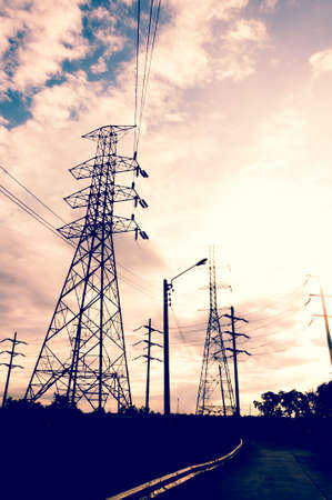 Energy Distribution Network - Electricity Pylons against Orange and Yellow Sunsetの写真素材