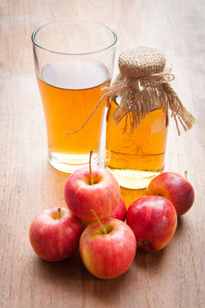 Glasses of apple juice with apples on the background.の写真素材