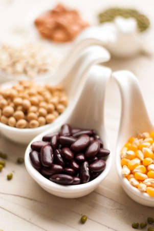 Different kinds of bean seeds, lentil, peas in dish on wooden table, macrobiotic food or healthy foodの写真素材