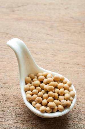 Soy beans in a white spoon isolated on white backgroundの写真素材