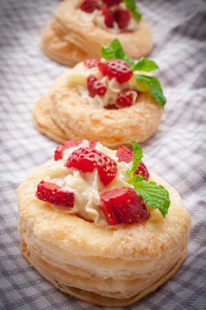 Strawberry Tart with Fresh Cream in Puff Pastry on wooden matの写真素材