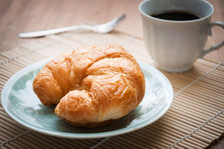 breakfast with croissants, cup of black coffeeの写真素材