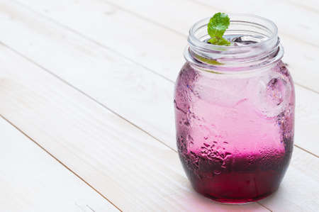 Chilled Red Grape Juice with soda on white wooden boardの写真素材