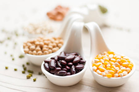 Different kinds of bean seeds lentil peas in dish on wooden table macrobiotic food or healthy foodの写真素材